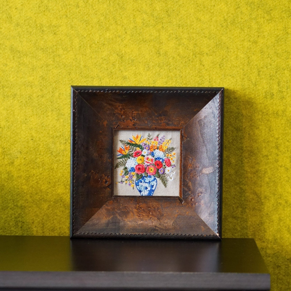 Framed linen embroidery with a colorful French country bouquet, styled as a personal silk or linen anniversary gift for the home