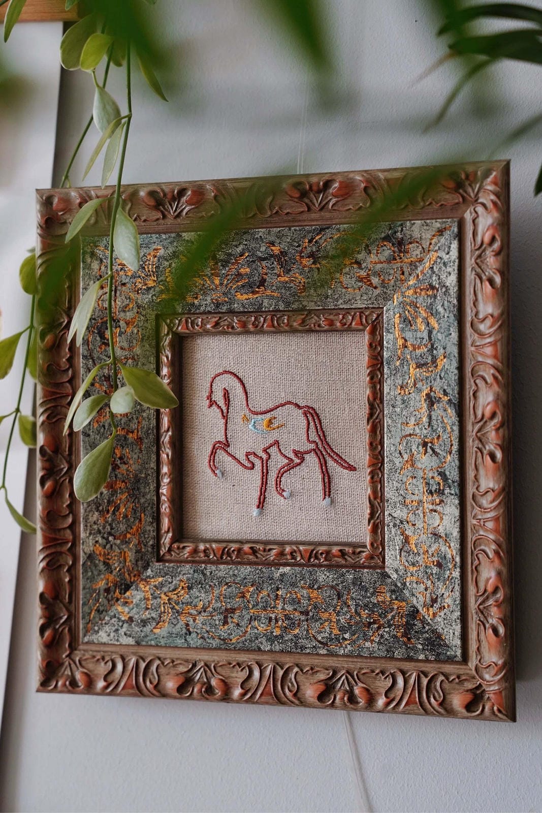 Small square framed linen embroidery illustrating wall art hanging height