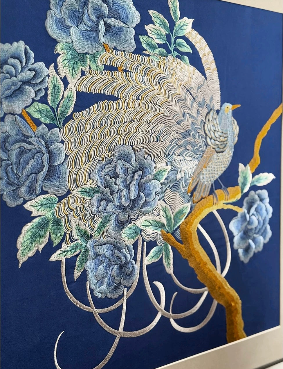 Detailed hand-embroidered peonies and bird showing varied stitch direction
