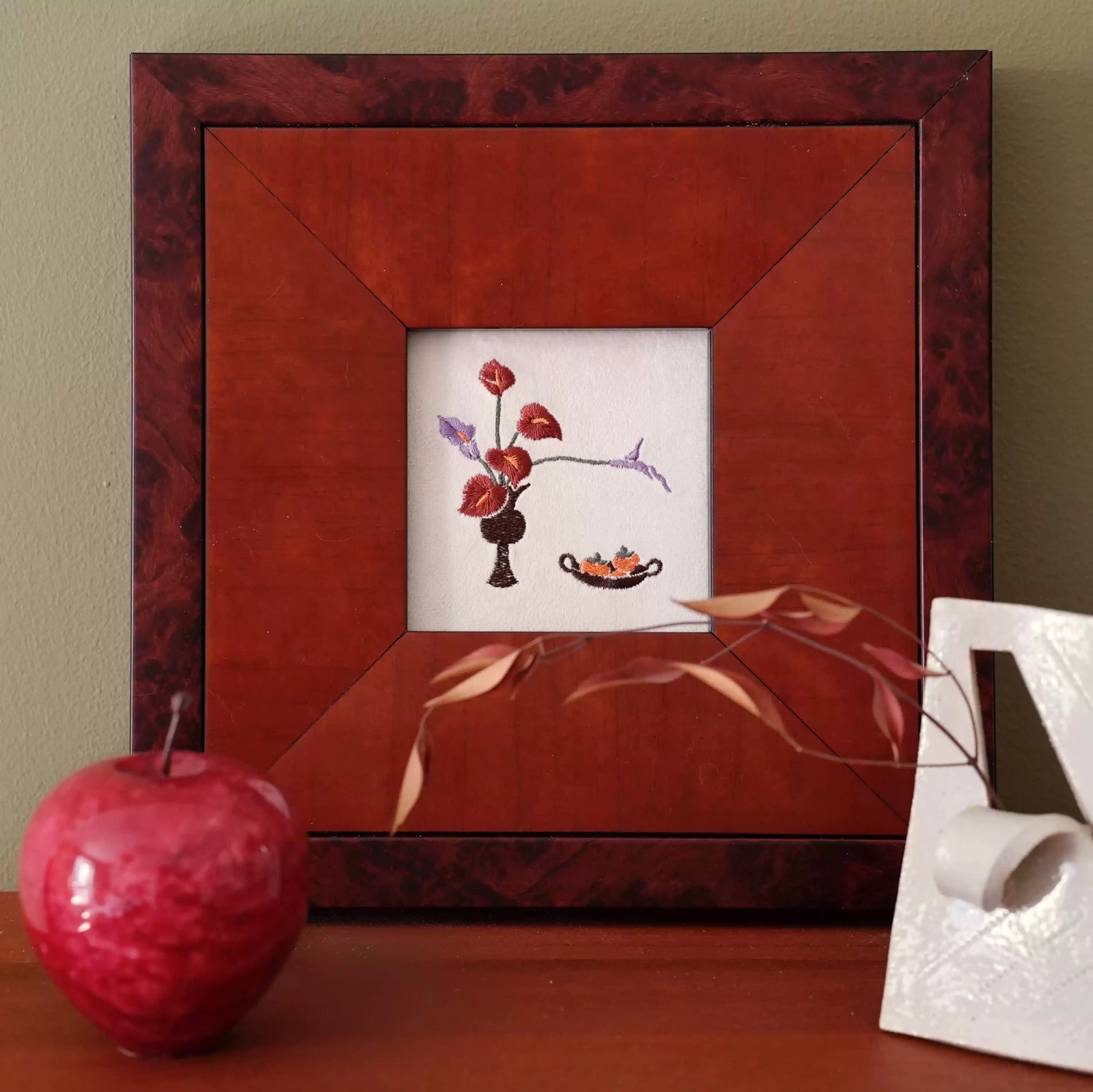 Detailed silk embroidery artwork adding visible handwork and tactile texture to a contemporary interior