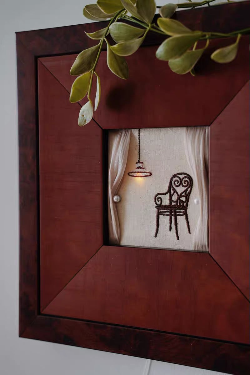 A cozy interior scene rendered in framed embroidery, illustrating a personal and layered home