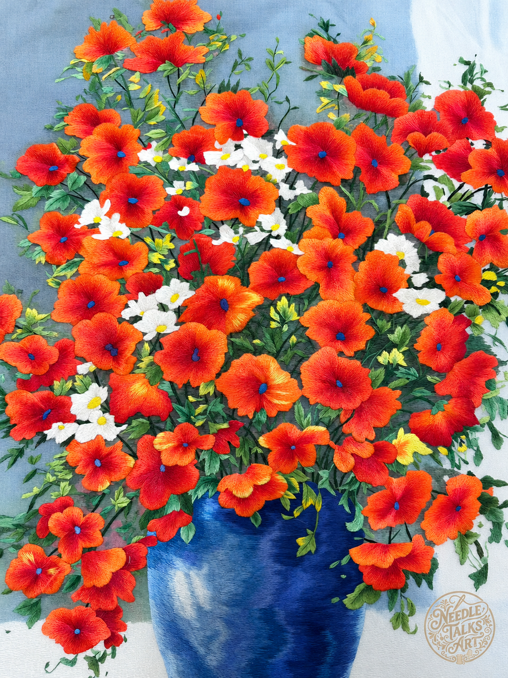 Close-up of The Joy of Blooming silk embroidery with red-orange blossoms, small white flowers and green leaves.