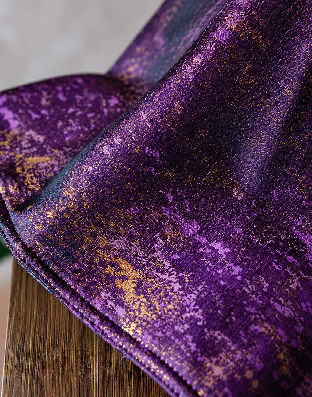 Detail of the Violet Dusk bag showing purple woven texture, scattered gold pattern and stitched edge.