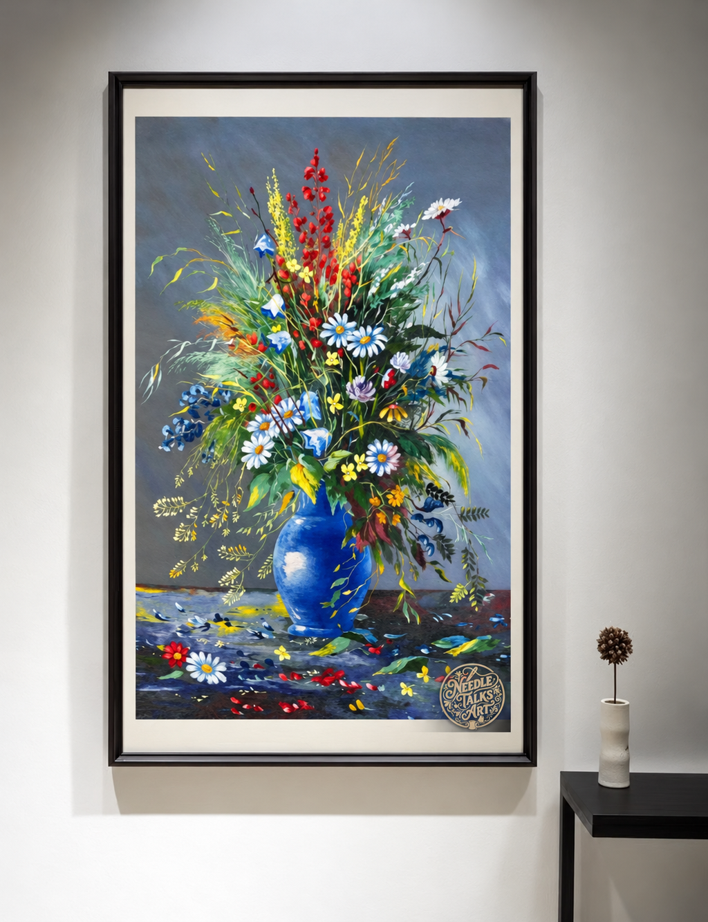 Where Wildflowers Gather embroidery shown in a black frame on a wall; framing inspiration for the unframed artwork.