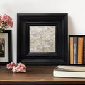 Square black bamboo-style wood frame with a shimmering white mother-of-pearl mosaic inlay, surrounding a central canvas print