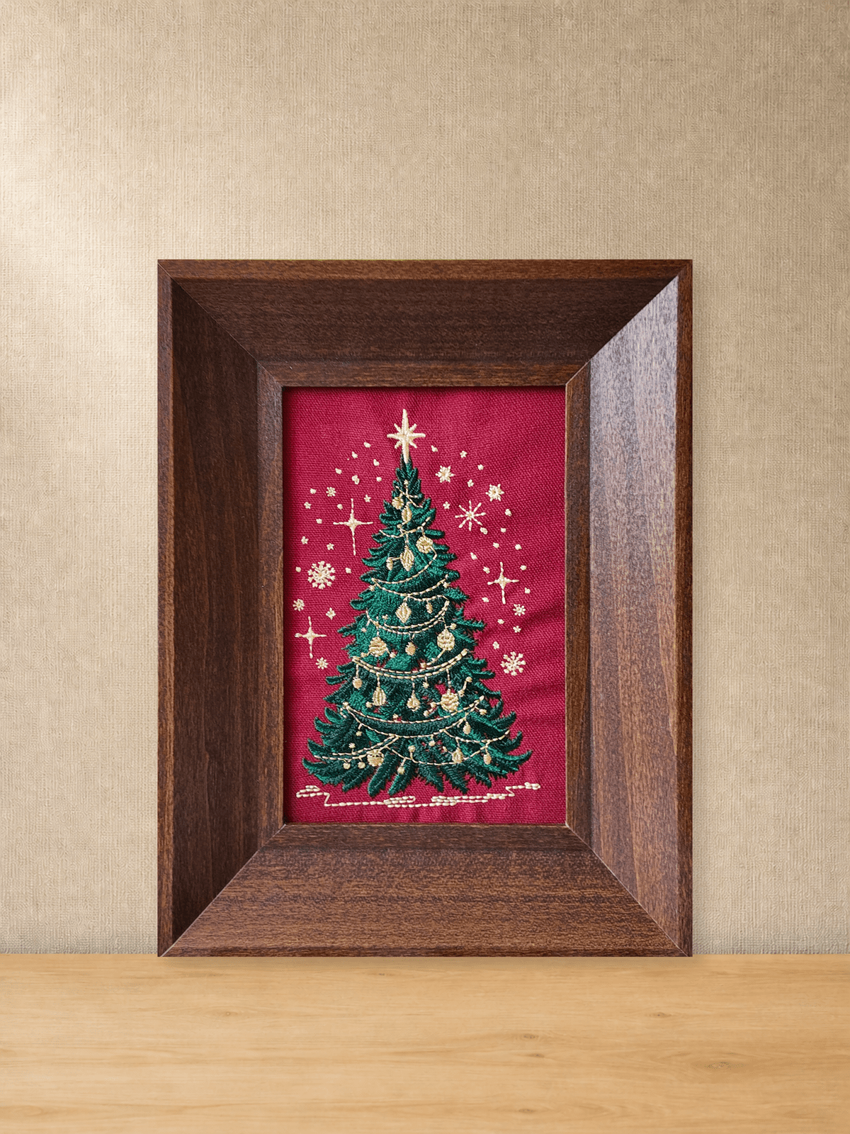 Framed Christmas tree embroidery in a brown wood frame on a tabletop