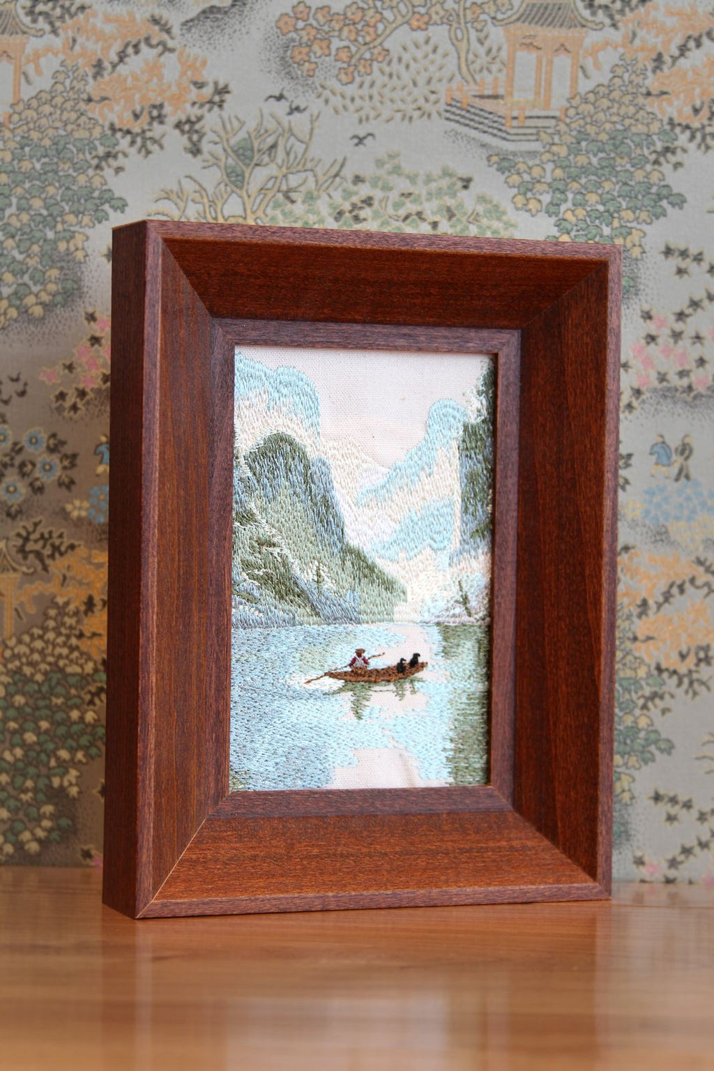 Angled view of Guilin karst embroidery in a brown wood frame