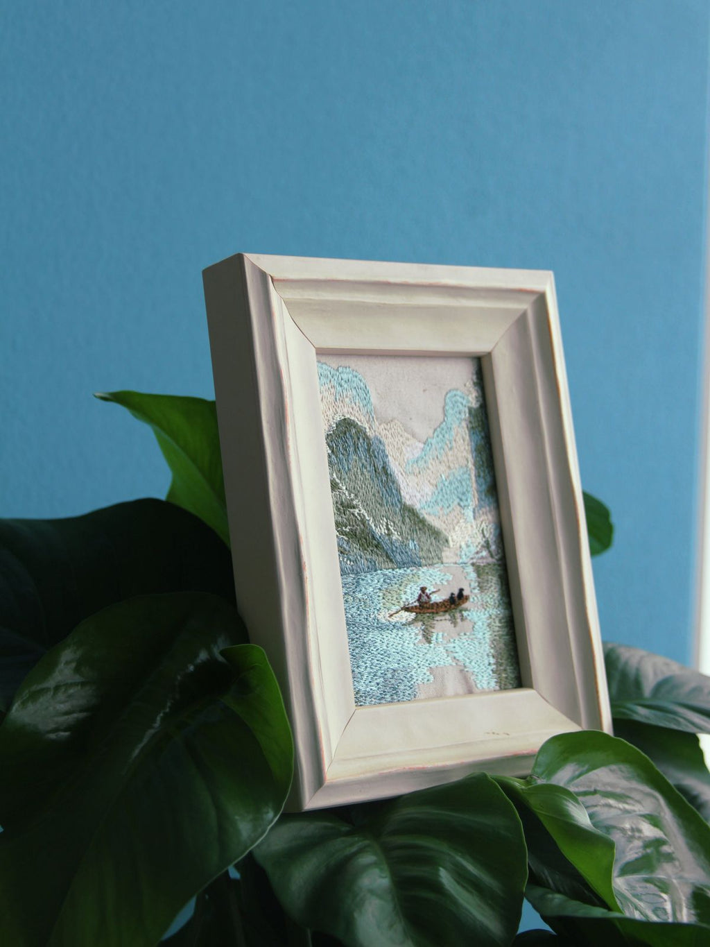 White framed Guilin landscape embroidery styled among green plants