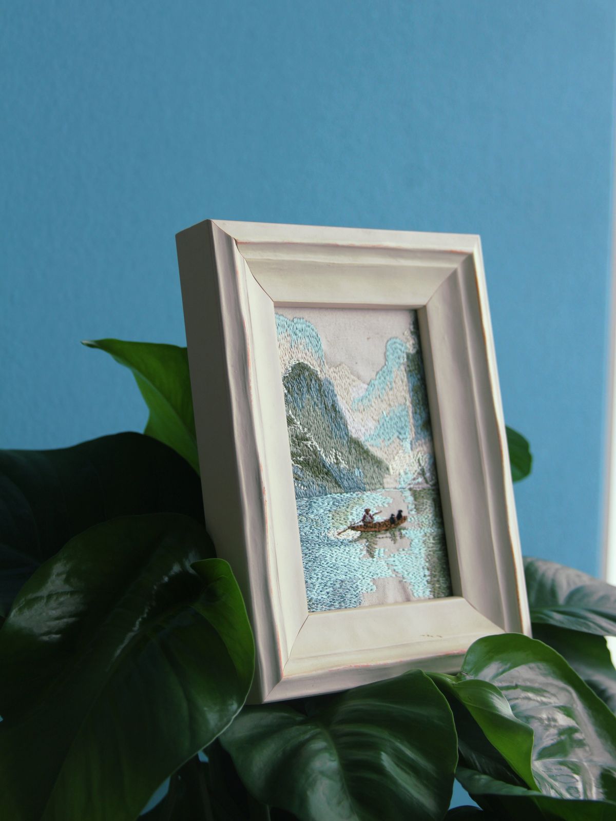 White framed Guilin landscape embroidery styled among green plants