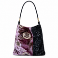 Purple floral velvet and black sequin shoulder bag with black leather strap, front view on white.