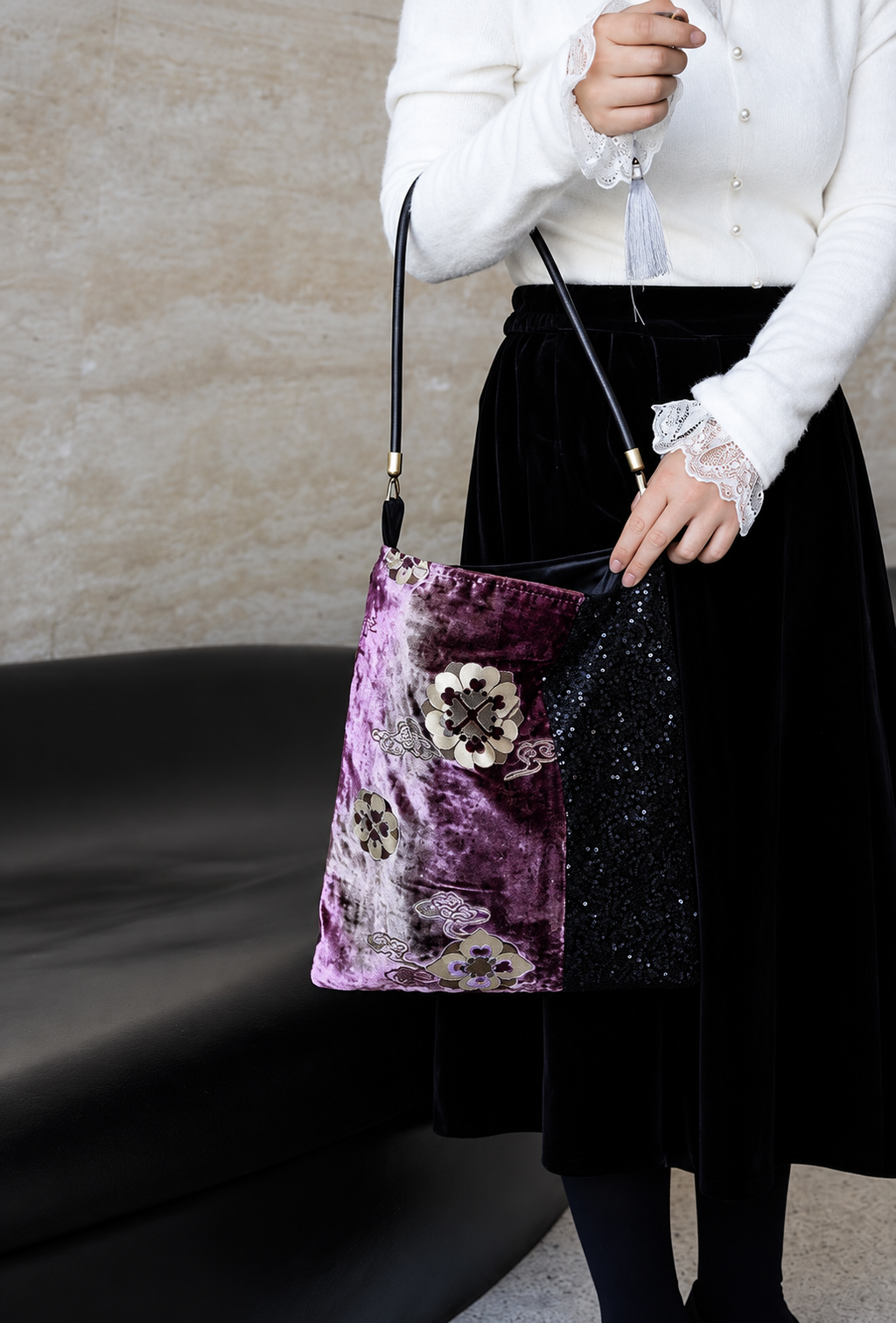 Purple floral velvet and sequin shoulder bag styled with a black skirt.