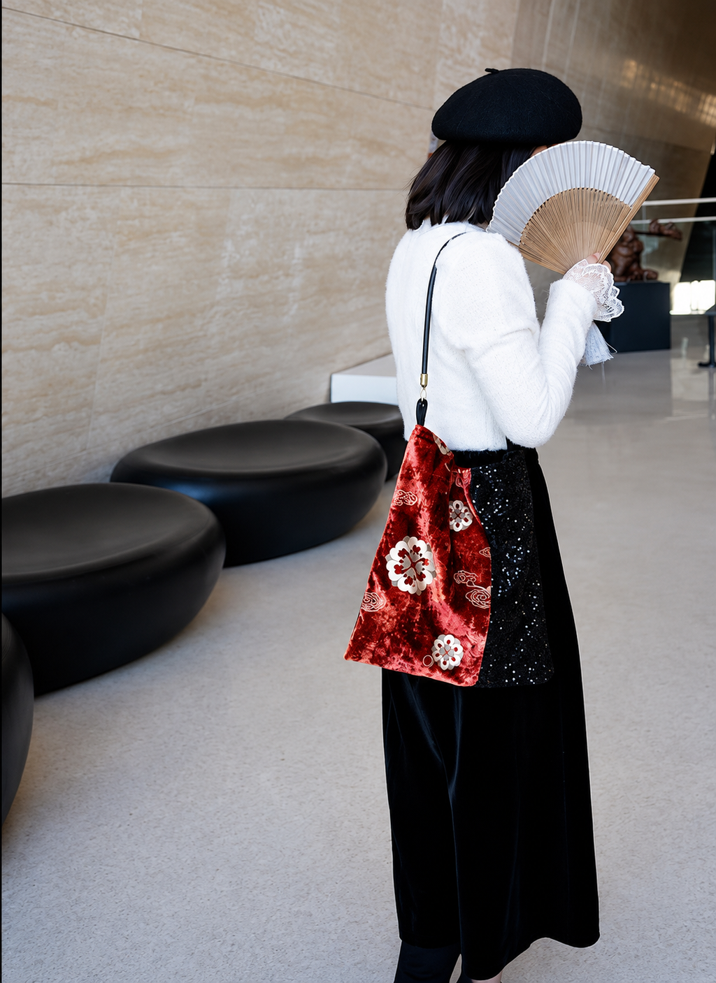 Red floral velvet and black sequin shoulder bag worn over the shoulder.