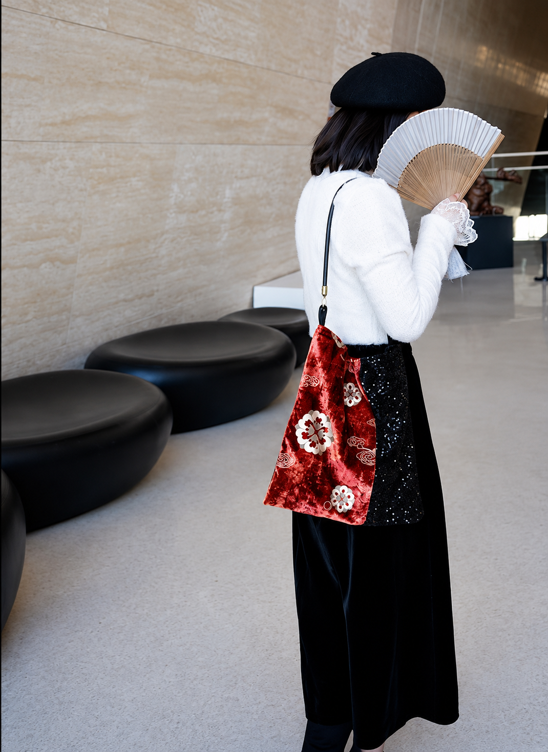 Red floral velvet and black sequin shoulder bag worn over the shoulder.