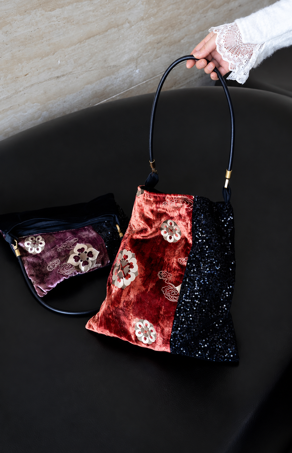 Red and purple floral velvet shoulder bags displayed together with black sequin panels.