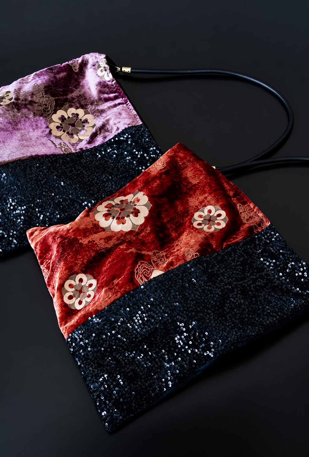 Red and purple floral velvet shoulder bags with black sequin panels arranged together.