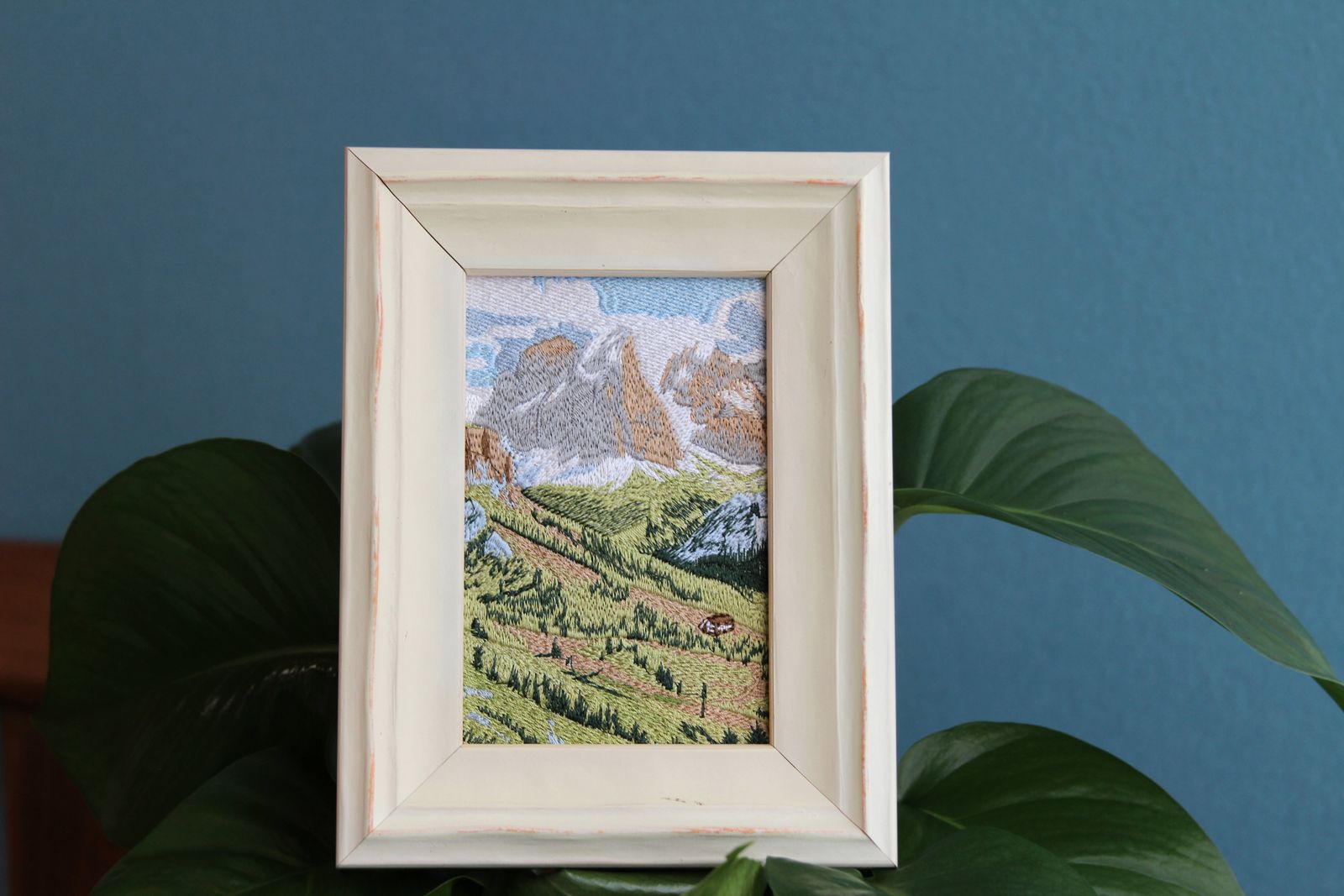 White framed Swiss alpine embroidery styled among green plants